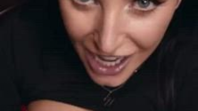 Angela White happily jerking a load on her tits in black top